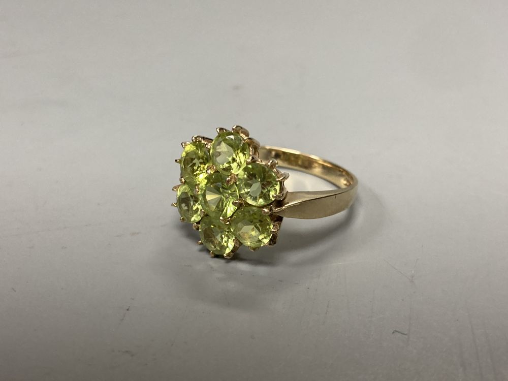 A modern 9ct gold and seven stone peridot cluster ring, size P, gross 3.4 grams.